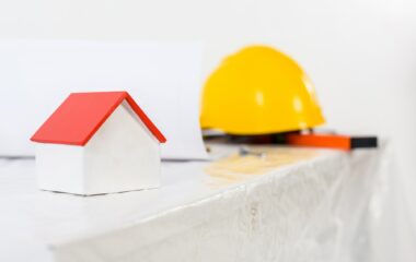 yellow helmet and small house on table